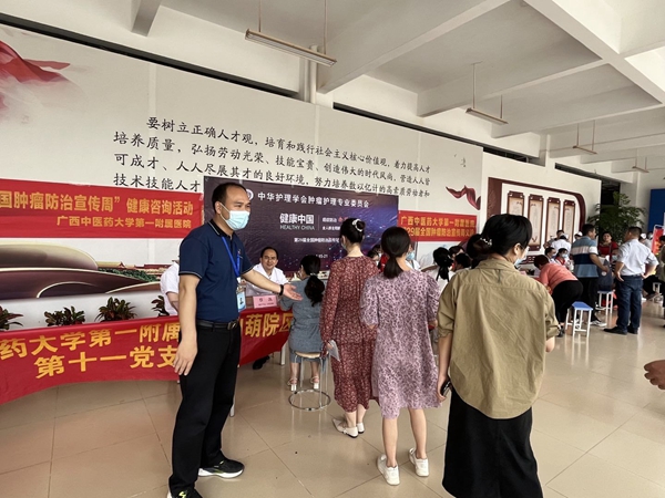广西二轻技师学院第二党支部委员贾燕学在义诊活动现场做引导.jpg