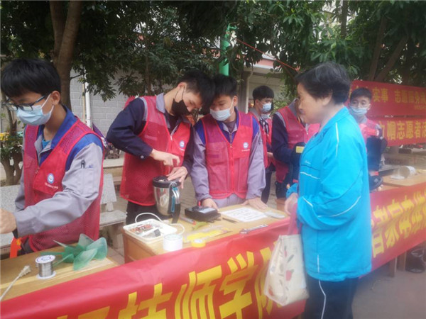 学院青年志愿者给社区群众维修电器.jpg 学院青年志愿者给社区群众维修电器.jpg